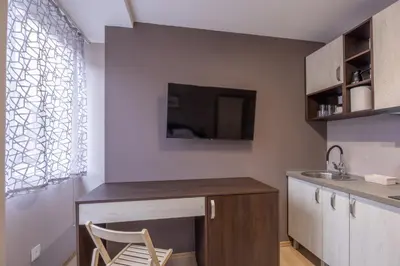 a kitchen with a table and a chair and a sink at Center Prestige Apartments in Belgrade