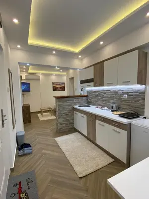 a kitchen with white cabinets and a counter top at Surčin Centar apartment in Surčin