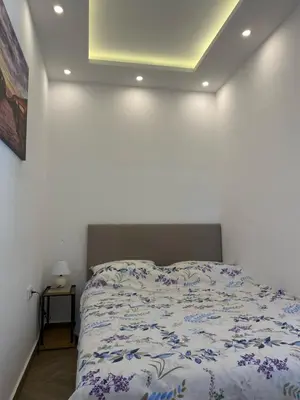 a bed in a room with a white wall at Surčin Centar apartment in Surčin