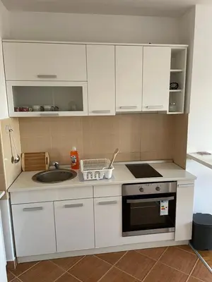 a kitchen with white cabinets and a sink at LV Apartments in Belgrade