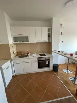 a kitchen with white cabinets and a stove top oven at LV Apartments in Belgrade