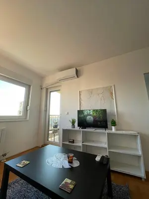 a living room with a table and a tv at LV Apartments in Belgrade