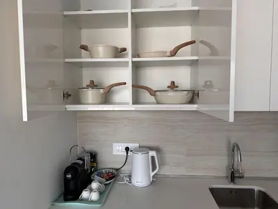 a kitchen with white cupboards with pots and pans at Beldorado Apartments - Belgrade Waterfront Luxury Apartment Amber in Belgrade