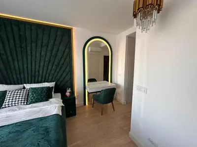 a bedroom with a large green headboard and a mirror at Beldorado Apartments - Belgrade Waterfront Luxury Apartment Amber in Belgrade