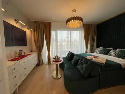a bedroom with a large bed and a chandelier at Beldorado Apartments - Belgrade Waterfront Luxury Apartment Amber in Belgrade