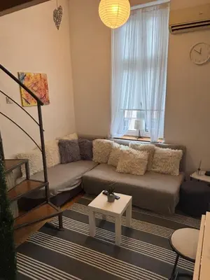 a living room with a couch and a window at Knez Mihailova apartment - City Center in Belgrade