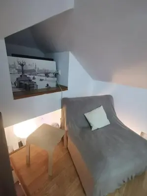 a small bedroom with a bed and a stool at Knez Mihailova apartment - City Center in Belgrade