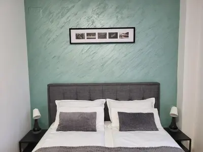 a bedroom with a bed with a green wall at Breeze Apartment in Žarkovo
