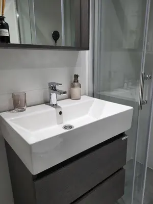 a bathroom with a white sink and a shower at Breeze Apartment in Žarkovo