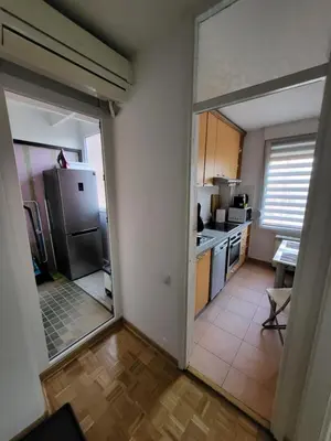 a kitchen with a door open to a kitchen with a refrigerator at Breeze Apartment in Žarkovo