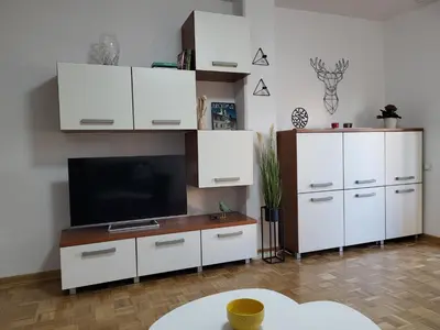 a living room with white cabinets and a flat screen tv at Breeze Apartment in Žarkovo