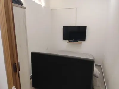 a flat screen tv on a wall with a chair at The nest in Dušanovac (historical)