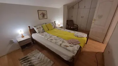 a small bedroom with a bed with a yellow blanket at Sky Loft in Belgrade