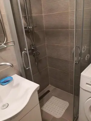 a bathroom with a shower with a sink and a toilet at Sky Loft in Belgrade