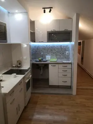 a kitchen with white cabinets and a sink at Sky Loft in Belgrade