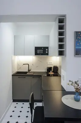 a kitchen with white cabinets and a black table and a table at Central life in Belgrade