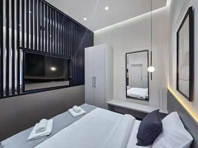 a bedroom with a white bed and a tv at Central life in Belgrade