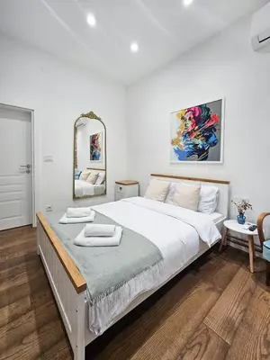 a bedroom with a large white bed with a mirror at Easy life in Belgrade