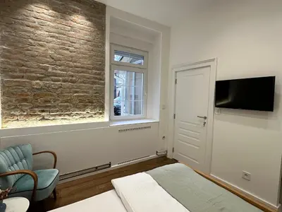 a bedroom with a brick wall and a tv at Easy life in Belgrade
