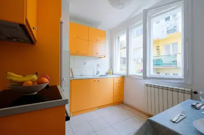 a kitchen with orange cabinets and a bowl of fruit on a counter at Bright & Quiet - Skadarlija in Belgrade
