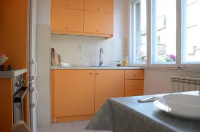 a kitchen with orange cabinets and a sink at Bright & Quiet - Skadarlija in Belgrade