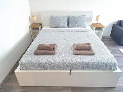 a white bed with two brown pillows on it at Bright & Quiet - Skadarlija in Belgrade