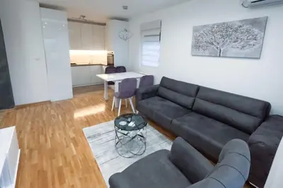 a living room with a black couch and a table at Urban Haven in Ledine