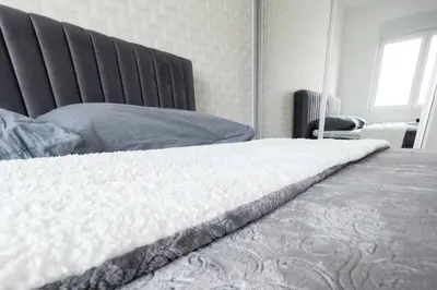 a bedroom with a white bed and a chair at Urban Haven in Ledine