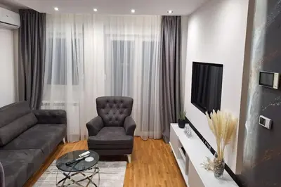 a living room with a couch and a chair and a television at Urban Haven in Ledine