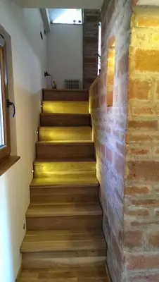 a staircase with a brick wall and wooden steps at Kuca na Savi - Stari hrast in Vladimirci