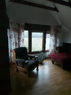 a living room with a chair and a red couch at Kuca na Savi - Stari hrast in Vladimirci