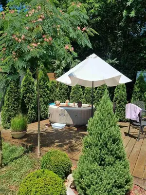 an umbrella and a hot tub in a garden at Kuca na Savi - Stari hrast in Vladimirci