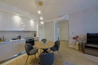 a kitchen and living room with a table and chairs at SD Luxury Apartment - Belgrade Waterfront in Belgrade