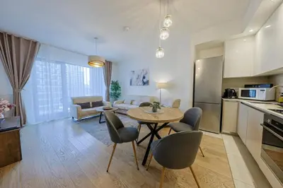 a kitchen and living room with a table and chairs at SD Luxury Apartment - Belgrade Waterfront in Belgrade