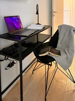 a black desk with a laptop computer on a chair at SD Luxury Apartment - Belgrade Waterfront - KARE Design - River View in Belgrade