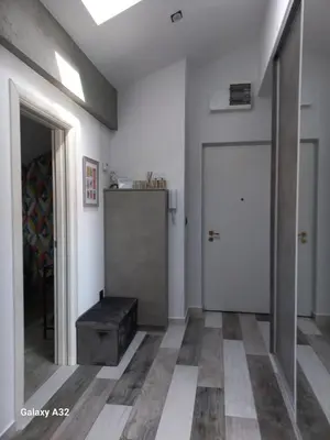a hallway with a door and a stool in a room at New Grey in Novi Beograd