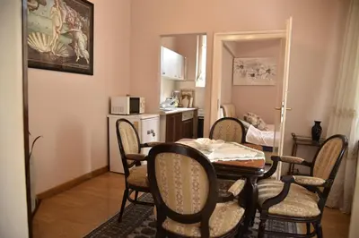 a dining room with a table and chairs and a kitchen at Belgrade Center Bohemian Quarter in Belgrade