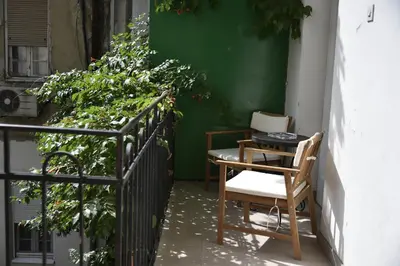 a table and chairs on a balcony with plants at Belgrade Center Bohemian Quarter in Belgrade
