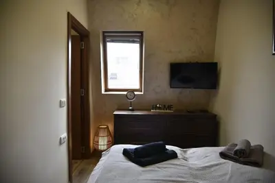 a bedroom with a bed and a television and a window at Belgrade Center Penthouse Duplex in Belgrade