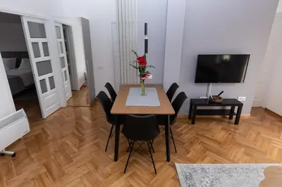 a dining room with a table and chairs and a television at Centrum 3 in Belgrade