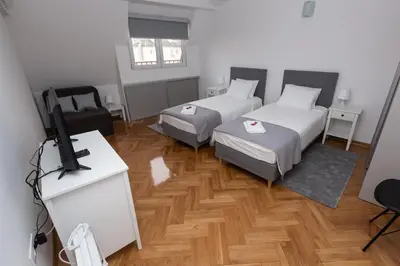 a room with two beds and a flat screen tv at Centrum 3 in Belgrade