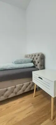 a bed in a room with a white table at Magenta Zvezdara in Belgrade