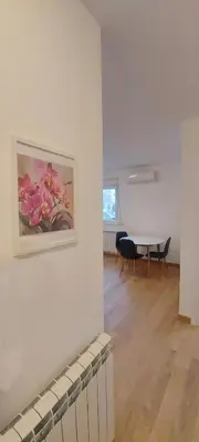 a room with a table and a painting on a wall at Magenta Zvezdara in Belgrade