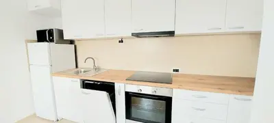 a kitchen with white cabinets and a sink at Magenta Zvezdara in Belgrade