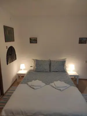 a bedroom with a large bed with two tables at Apostolovic kuca kulturni spomenik u centru Grocke in Grocka