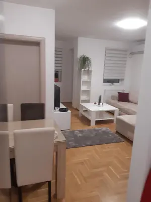 a living room with a table and a couch at Stil Apartman in Smederevo