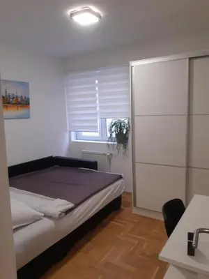 a bedroom with a bed and a window at Stil Apartman in Smederevo