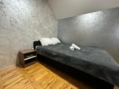 a small bedroom with a bed and a table at GM Apartman Obrenovac in Obrenovac