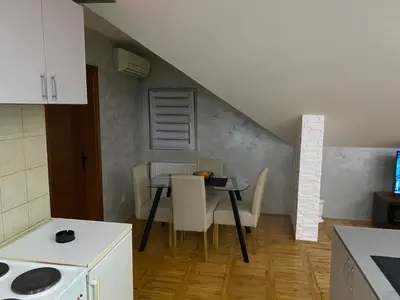 a kitchen with a table and chairs in a room at GM Apartman Obrenovac in Obrenovac