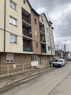 a van parked in front of a tall building at GM Apartman Obrenovac in Obrenovac
